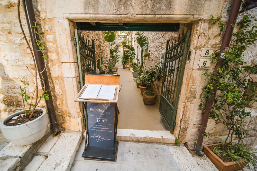 Outdoor terrace at Paradise Garden restaurant in Hvar with lush greenery